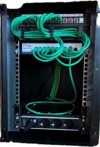 Echte Projektaufnahme eines fertig eingerichteten Netzwerkschranks mit grünen Patchkabeln, Patchpanel, Switch und Stromverteilung